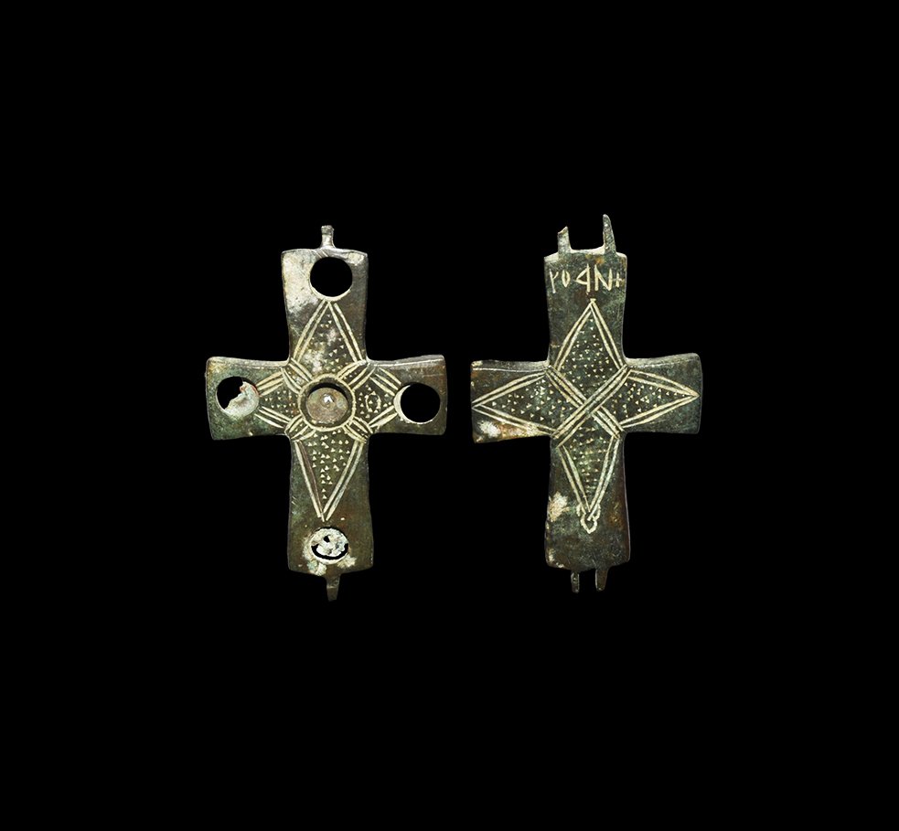 Byzantine Geometric Inscribed Reliquary Cross Pendant: 8th-9th century AD. A bronze enkolpion or hollow-formed reliquary cross pendant with incised quatrefoil motif to each broad face, pecked texturing; to the obverse five round recesses to accept inset g