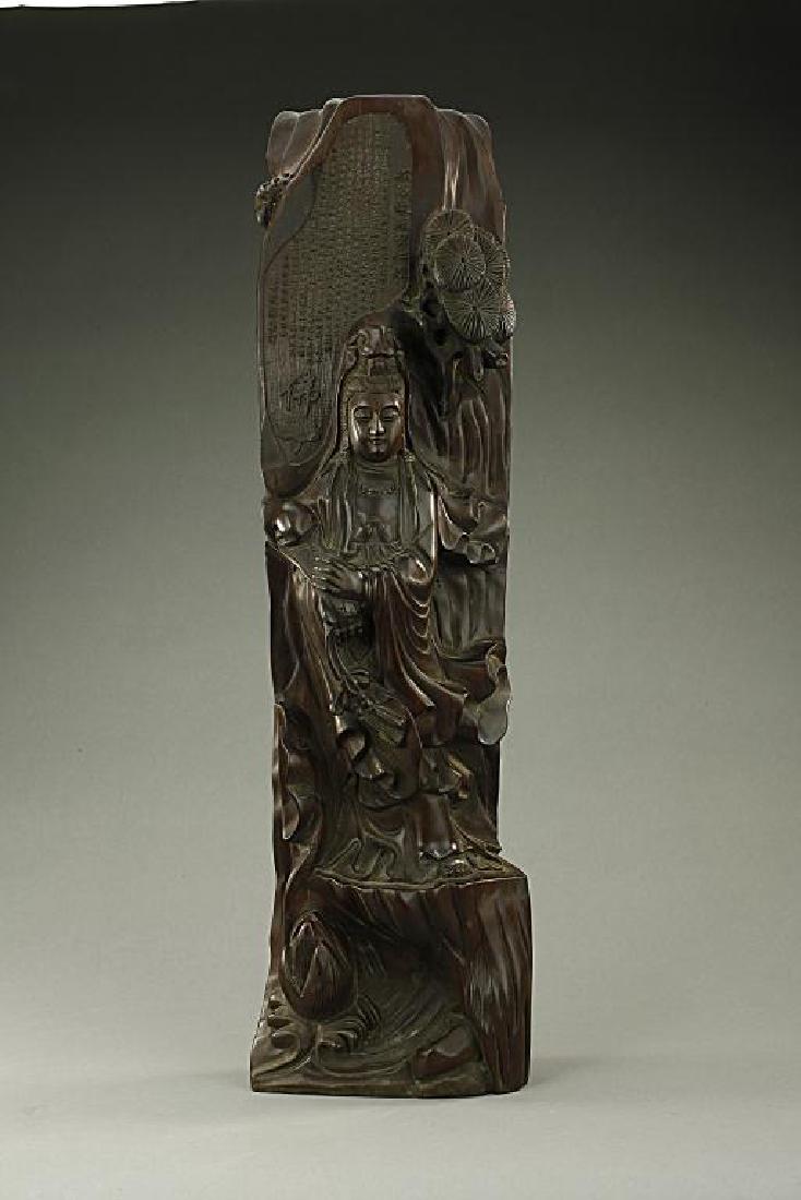 CHINESE CARVED WOODEN FIGURE OF A STANDING GUANYIN: With a serene face, wearing loose robes with a sense of movement and holding a scepter. Upon the head of the Guanyin, sutra is inscribed. H: 21 in.