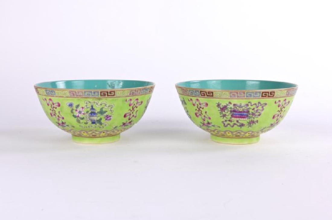 A PAIR OF ANTIQUE FAMILLE ROSE YELLOW-GROUND BOWLS: With rounded curving sides raised on a short straight foot. The exterior painted with "eight Buddhist emblem" in yellow, blue, red and green. Interior painted with turquoise glaze. Six character mark 