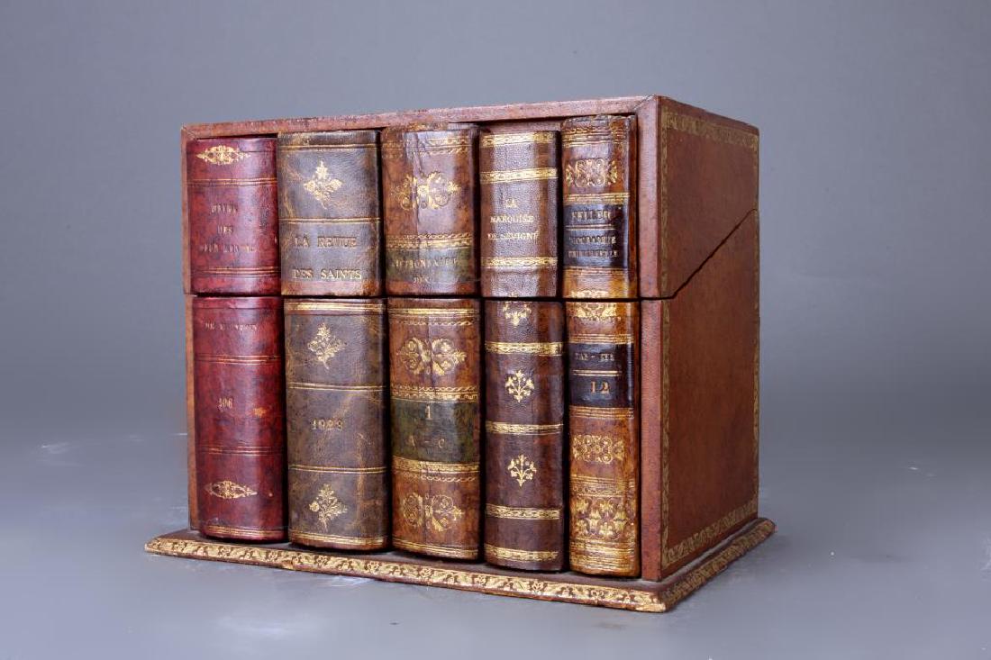 FRENCH FAUX BOOK BOX TANTALUS LIQUOR SET: Comprising of a light yellow cut glass decanter, with four wine glasses with gold rim.