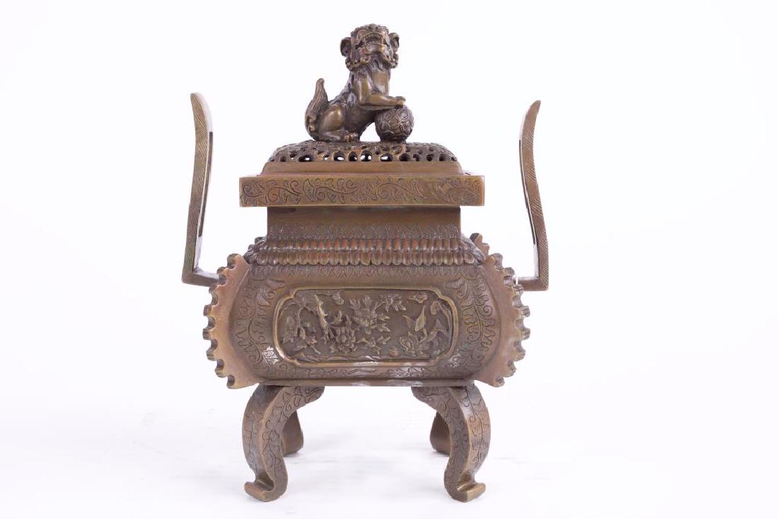 PAIR OF CHINESE BRONZE CENSER BURNERS: Of oblong formed body supported by four feet. Cover surmounted by a foo lion finial. all beneath a band on the shoulder. H: 9 1/4 in.