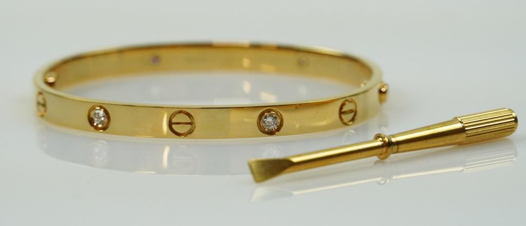 18K VINTAGE YELLOW GOLD CARTIER-STYLE BANGLE: With a screwdriver accessory. Size: 18.