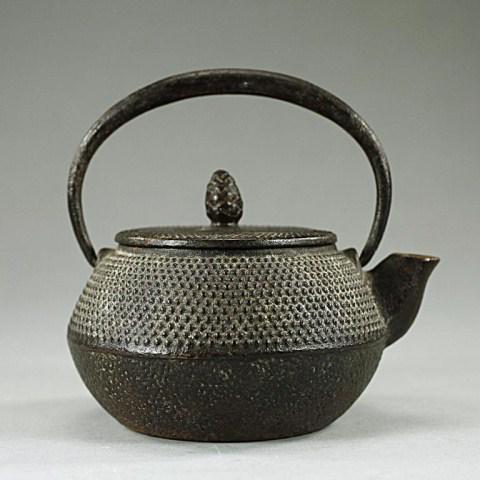 JAPANESE IRON TEAPOT: With raised dot design on upper half of the body. H: 4 3/8 in.