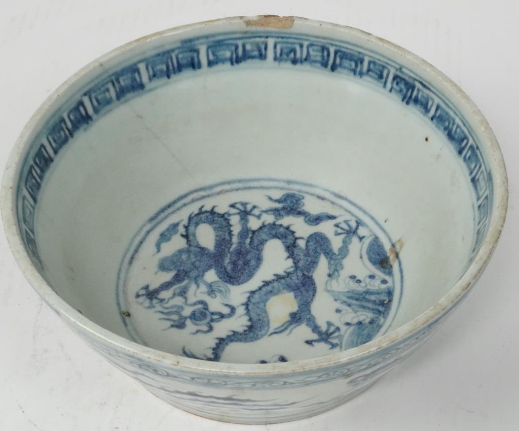 MING DYNASTY CHINESE BLUE AND WHITE BOWL: Of Ming dynasty. Beautifully painted with phoenixes soaring in the sky on the exterior, with a dragon and a flaming peal in the center. Not in perfect condition. H: 3 1/4 in. D: 8 7/8 in.