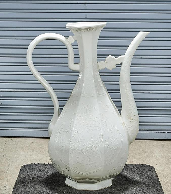 LARGE CHINESE WHITE GLAZED EWER: Beautifully decorated in low relief all over. Flanked by a spout and a high handle. H: 35 in. (88.9 cm)