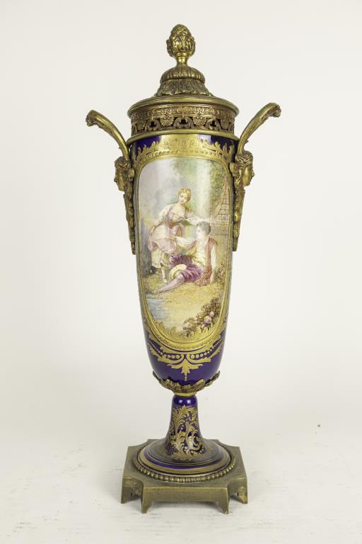 FRENCH SEVRES COBALT BLUE BACKGROUND COVERED VASE: Flanked by two gilt bronze high handles on the sides with a face of nymph. Beautifully hand-painted with a cameo of a love scene in the front; and a cameo of a landscape scene on the back. Mounted on 