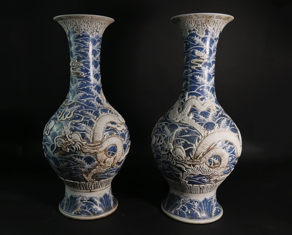 PAIR OF CHINESE BLUE AND WHITE GLOBULAR VASES: Each vase if finely carved in details of a soaring dragon chasing a flaming pearl over roaring waves. H: 27 3/4 in.