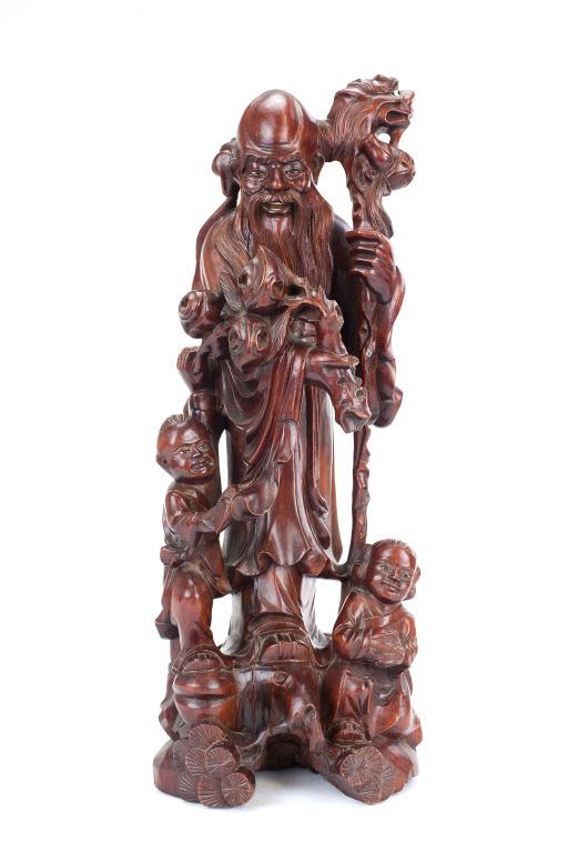 HARDWOOD CHINESE CARVED LUOHAN: Holding a tall staff shaped like a dragon and a peach tree branch. With two children at his side. H: 18 3/4 in.