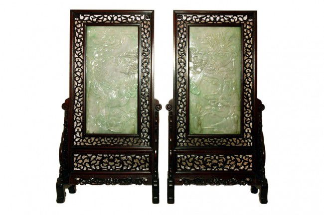 FINE LARGE PAIR OF CARVED JADEITE TABLE SCREENS: H: 23 1/2" x L: 11 1/8" with frame H: 41 3/8" x L: 20 5/8", in reticulated wood frame on stand, with image of a four- clawed dragon in one panel, and a phoenix on the other