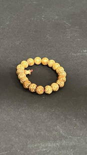 CHINESE BEADED BRACELET: Each bead is of mottled brownish yellow color.