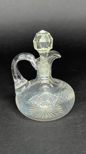 BULBOUS GLASS DECANTER WITH STOPPER: Flanked by a high handle, with a diamond shape stopper.