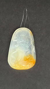 A MULTI-COLORED PENDANT: Of translucent yellow and white colors, carved with a Guanyin.