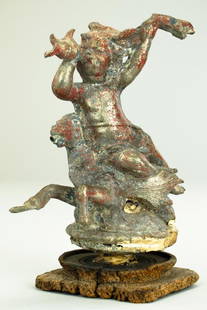 ANTIQUE EUROPEAN BRONZE FIGURE OF A PUTTI: Patinated with remnants of red paint to be seen. The putti rides upon a horse with the tail of a fish, while blowing into a conch shell. Mounted onto an antique wood base. H: 8 1/2 in.