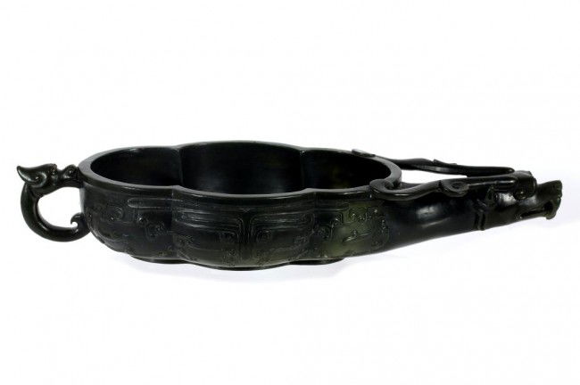 CHINESE CARVED SPINACH JADE STYLE VESSEL: L: 10 1/2 in. (27cm), issuing from the dragon's head to the body to form a scrolled cavity as vessel, a dragon-headed fish attached as a tail cum handle, exterior carved with Tao tsie mask