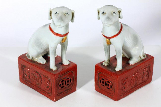 PAIR OF CHINESE PORCELAIN DOG FIGURES: H: 6 3/4 in. (17cm), charmingly seated on a reticulated stand decorated with shou mark between bats
