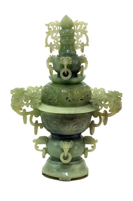 JADEITE CENSER WITH COVER: H: 13 in. (33cm), composed of four sections on domed base; the lower globular jar decorated with four applied elephant head's masks with loose rings, supporting a deeply carved censer-like body flanke