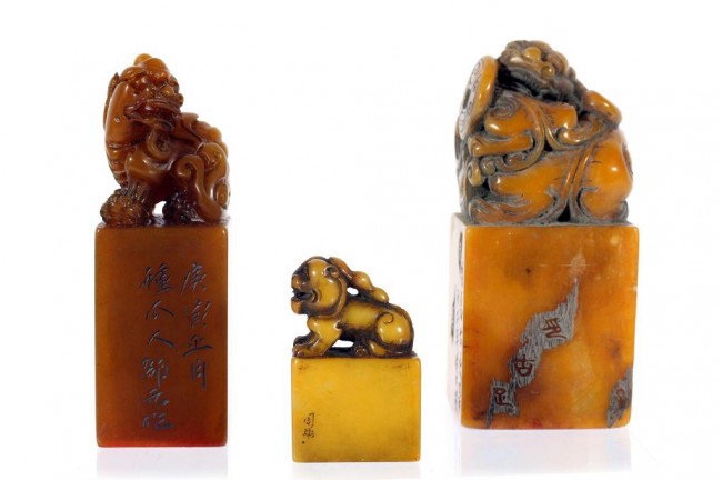 SET OF THREE CHINESE SOAPSTONE SEALS: H: 3 3/4 in. (9.5cm), two with carved foo dog finials, and one with a foo lion, a dragon, and a bi disc