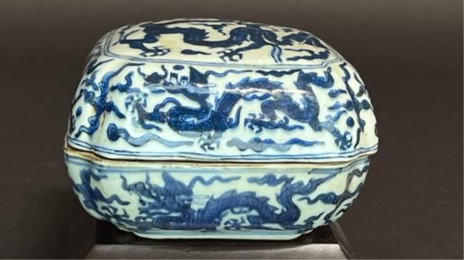 CHINESE BLUE AND WHITE PORCELAIN BOX: Square-shaped. Depicting of dragons chasing pearls. Six-character mark on the base H: 3 3/4 in.