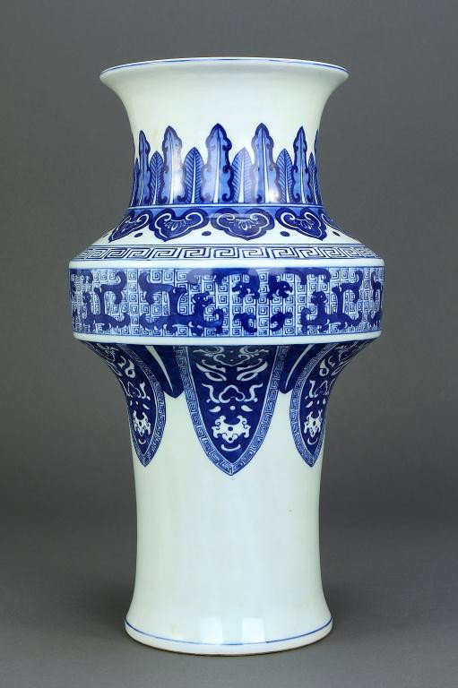 CHINESE BLUE AND WHITE PORCELAIN VASE: H: 12 1/4 in. (31cm), the lower body decorated with lappets painted with tao tie mask with bats and peaches, flared to hold the round midsection bearing pairs of qilins on a leiwen diaper band below g