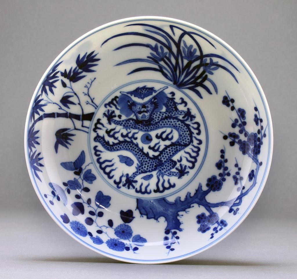 CHINESE BLUE AND WHITE 'DRAGON' SHALLOW DISH: Diameter: 7 1/2 in. (19cm) x H: 1 5/8 in. (4.1cm) with five clawed, scaly dragon chasing a flaming pearl amid clouds inside the central medallion. Guangxu character mark at the base.