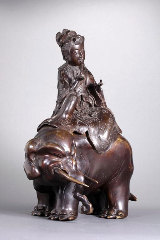 JAPANESE BRONZE CENSER, OF A GUANYIN ON ELEPHANT: H: 14 in. (35.6cm), in an unusual form of a lady in a finely chased robe aboard an elephant with its head turned to the right.
