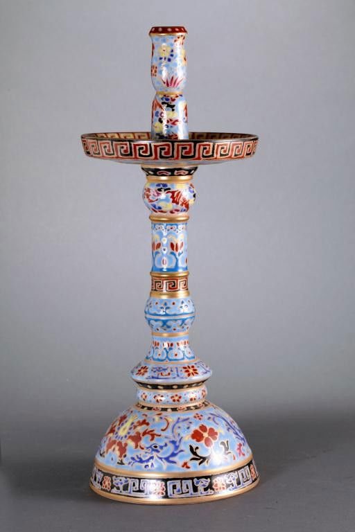 CHINESE FAMILLE ROSE PORCELAIN CANDLESTICK: enameled with floral motif throughout a slender sectional cylindrical neck issuing from a domed foot, with a drip plate, lei wei borders on the rims. Mark to read Qianlong reign on the base.