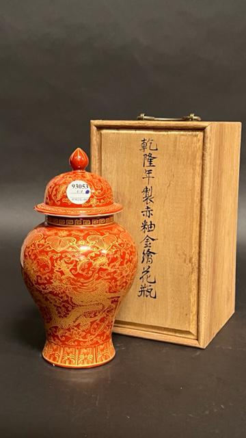A CHINESE ORANGE AND GOLD JAR AND COVER: Orange-ground body depicts of a gilded dragon under a border of ruyi heads and amidst blooms and tendrils. Cover has matching motif, and with an acorn finial. A six-character mark to read Qianlong in 