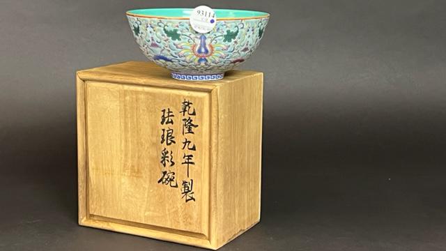 CHINESE GREEN BOWL, WITH INSCRIPTION ON THE BASE: Raised on a short leg, of concave form. Beautifully decorated with floral motif around the exterior. Inscription on the base to read Qianlong period. With a wooden box. H: 2 1/2 in. D: 5 7/8 in.
