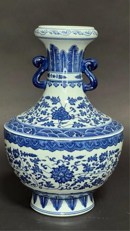 BEAUTIFUL CHINESE BLUE AND WHITE VASE: Raised on a sprayed leg. Beautifully painted with blossoming peonies and scrolling vines around the body as well as on the shoulder. Flanked by two handles on the neck. Six-character mark to read Qian