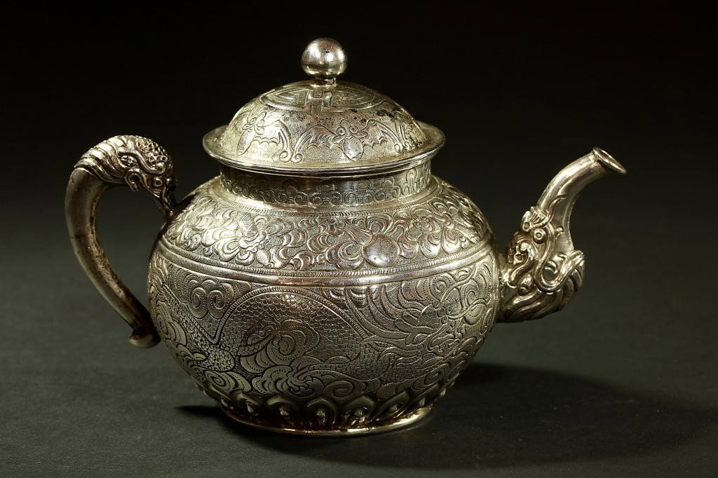 SMALL CHINESE SILVER TEAPOT: Late 19th/Early 20th Century. Decorated with auspicious signs, bats and dragons. Repose and channeling work, hand chased. H: 4 1/4 in.(11cm)