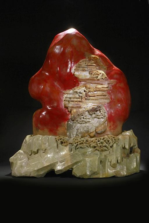 LARGE EXQUISITE CHINESE CARVED SOAPSTONE BOULDER: Beautifully carved soapstone, possibly of Taishan mountain with tmples on slopes beneath trees and behind bushes, mounted on a soapstone base with carved pine trees. L: 18 in. (45.7 cm), H: 20 1/2 in.