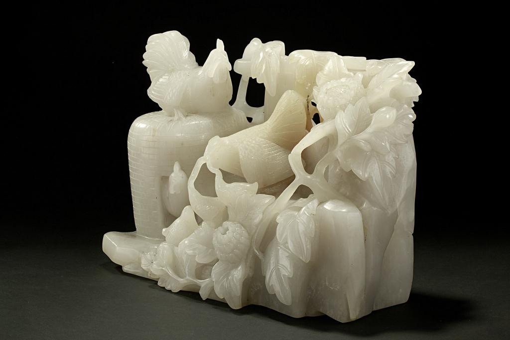 CHINESE WHITE JADE CARVING OF ROOSTERS: Amusing scene depicting of a mother hen feeding her chick, and roosters by the barnyard and beneath a gourd tree. L: 13 3/4 in. (35cm) x H:7 3/8 in. (23cm)