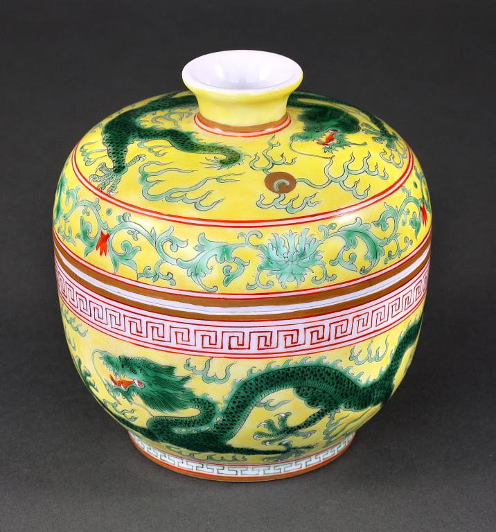 CHINESE FAMILLE JAUNE RICE BOWL WITH COVER: Carved in relief and hand-painted with dragons chasing flaming pearls between geometric borders around the globular body. The domed cover bears band of leafy branches below a lone dragon chasing a pea