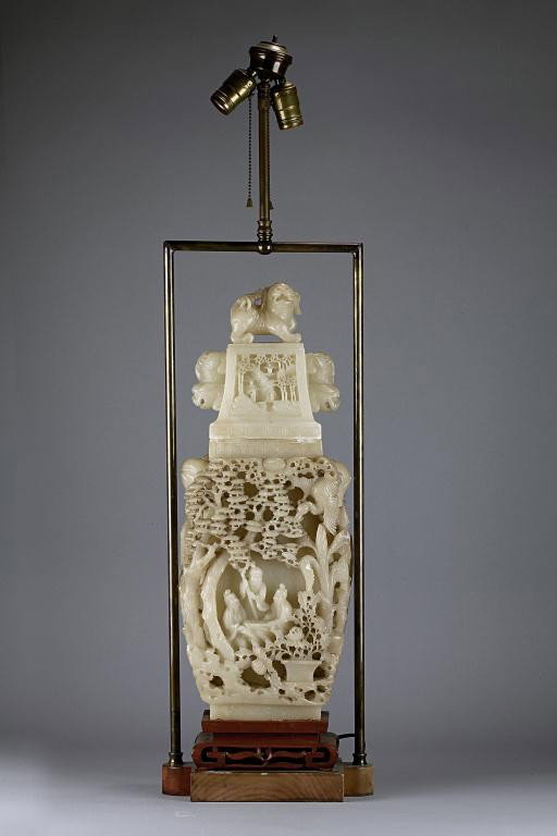 FINE ANTIQUE CHINESE CARVED SOAPSTONE COVERED VASE: Mounted as a lamp. Each side with elephant head handles and panels carved in high relief with scholars playing a board game under pine trees. The rectangular lid carved on both panels with temples ami