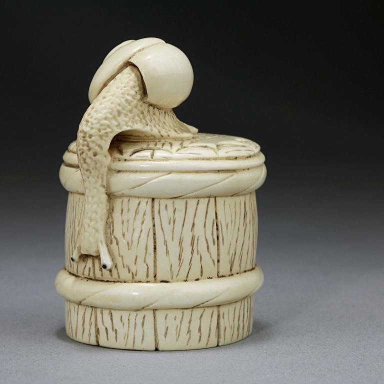 JAPANESE CARVED IVORY NETSUKE OF A SNAIL: From the Private Collection of Harry Lawrence of Laguna Beach. On a barrel. H: 1 3/4 in.(4.5cm)