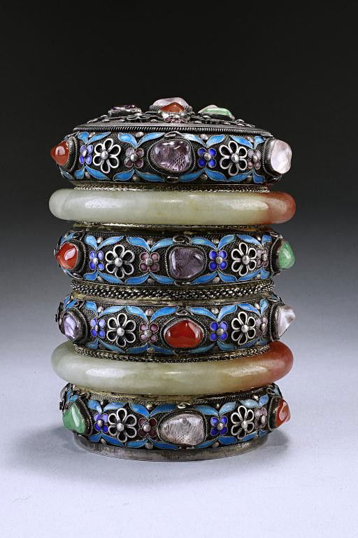 CHINESE SILVER ENAMELED AND BEJEWELLED BOX: From the Private Collection of Harry Lawrence of Laguna Beach. In rounded sectional cylindrical form, this stunning box and cover is adorned with semi-precious jewels, fitted jade bangle with hint of