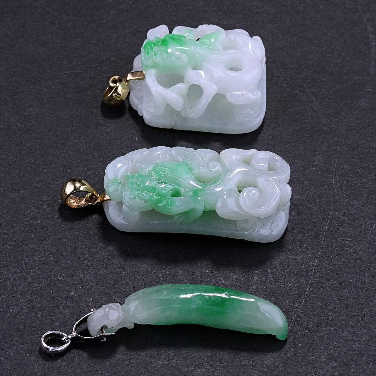 THREE PIECES OF CHINESE JADEITE PENDANTS: One in the form of a pepper in silver metal setting, and the other two of openwork beast carvings in gold settings. H: 1 3/8 in.(3.5cm)