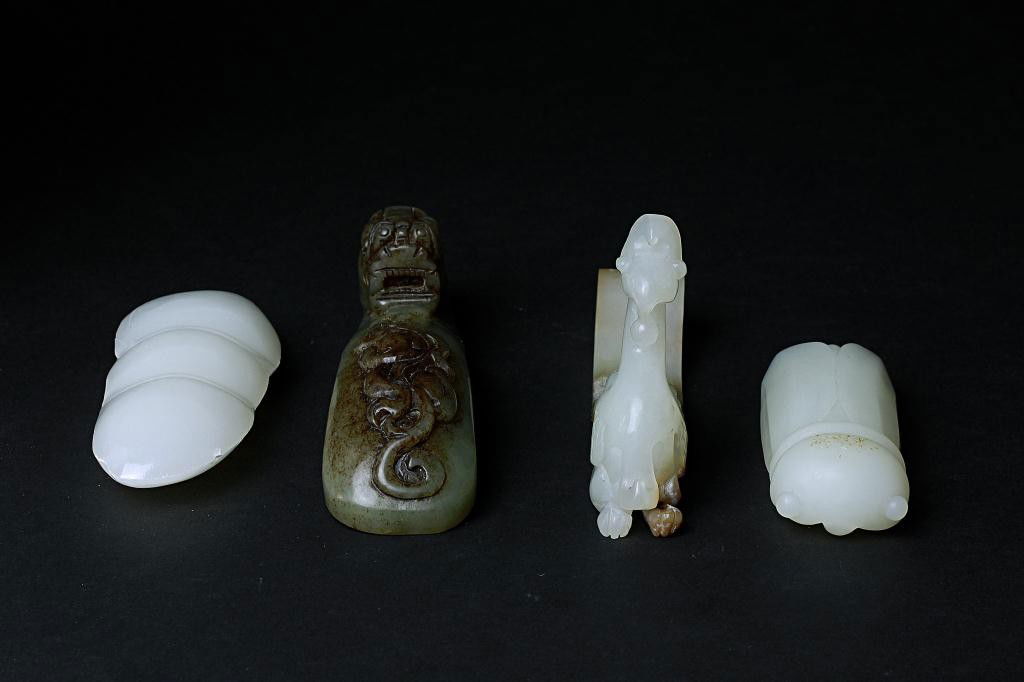 CARVED CHINESE JADE IMPLEMENTS: Consists of two table accessories in a form of a pea and a cicada; a carved dragon clothes hook; and a phoenix carved buckle. H: 4 3/4 in.(12cm)