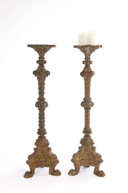 PAIR OF LARGE 18TH CENTURY CANDLEHOLDERS: Cast with scripting and foliate designs all over the body and base. Each standing on three short feet. H: 20 1/4 in.