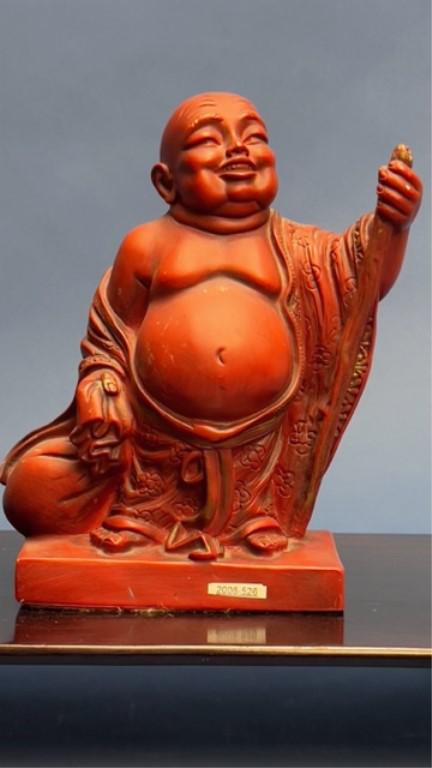 CHINESE CARVED FIGURE OF A HAPPY BUDDHA: Dressed in a loose robe and holding a bag and a staff. H:10 1/8 in.