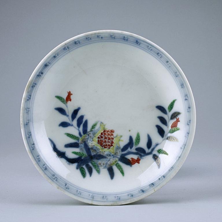 CHINESE FAMILLE ROSE DISH: The interior painted in bright enamels with pomegranate spray, an auspicious motif for “numerous sons” and key fret design around the rim, and enamelled around the exterior with blooms and tendril