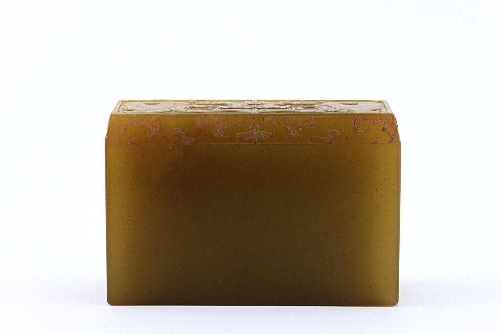 CHINESE SOAPSTONE SEAL: Carved on one side in low relief with formalized archaistic motif of the taotie mask, the reverse incised with a script. L: 4 1/8 in.(10.5cm) x W: 1 1/2 in.(4cm) x H: 2 3/4 in.(7cm)