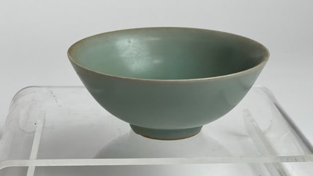 A CHINESE CELADON BOWL: Evenly conical shape raised on a smaller round base of the same color. H: 2 1/8 in. D: 5 1/2 in.