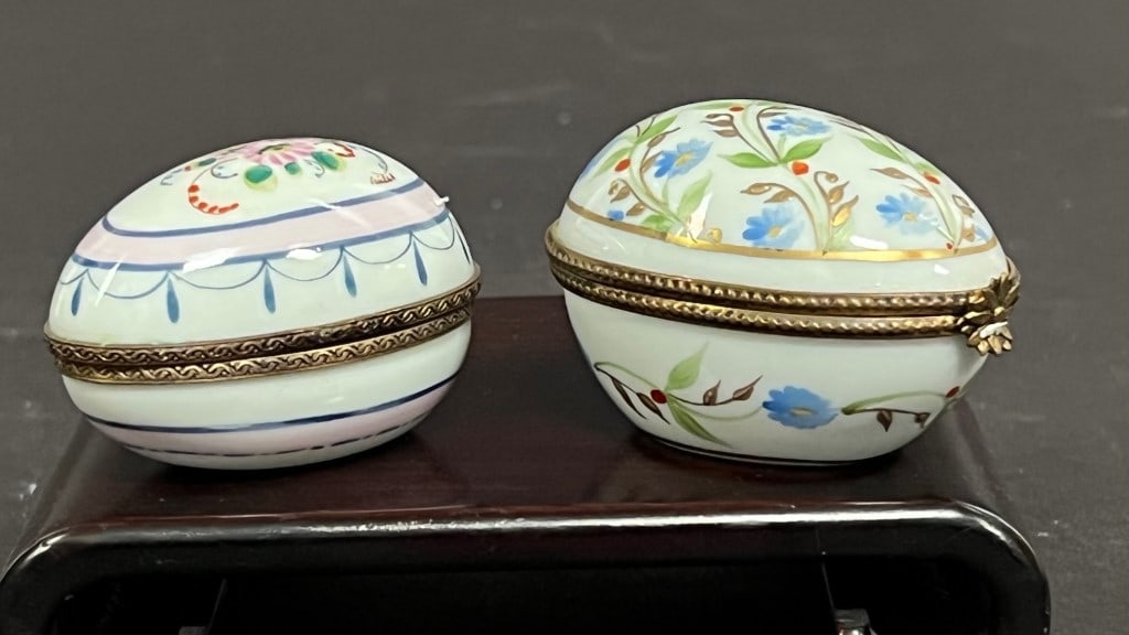 GROUP OF TWO EGG-SHAPED PILL BOXES: With gold-colored hardware and painted with dainty floral motif