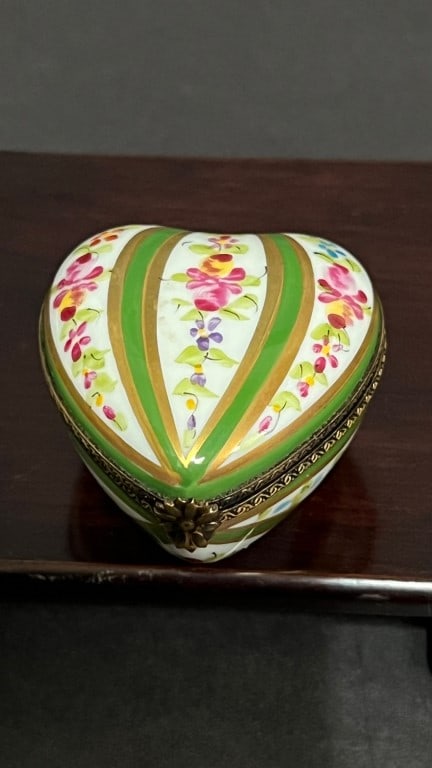 SMALL HEART-SHAPED PORCELAIN PILL BOX: With alternating green band and floral painting on white ground. Limoge inscription on the base.