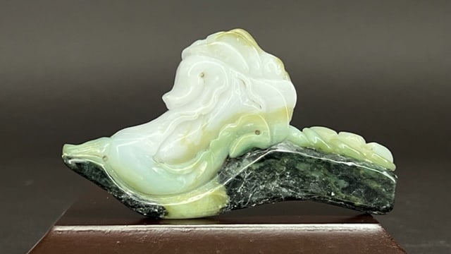 A JADE FIGURAL HORSE ON PLINTH: Moulded upper part of the horse cradled on a base.