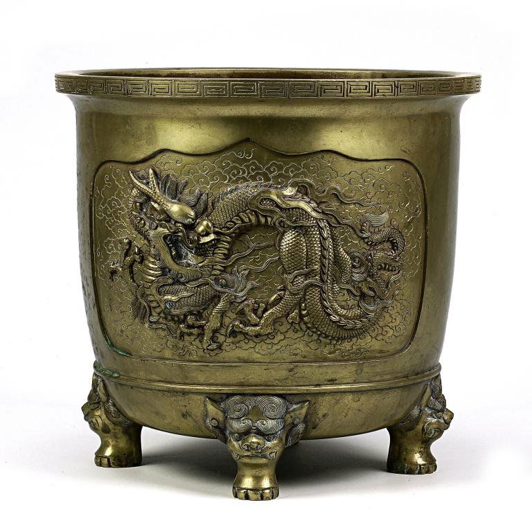 ANTIQUE 19TH CENTURY BRONZE JARDINIÈRE: standing on four legs in the shape of an animal's head, with two window panels framing a three clawed sinewy dragon in relief on each, stamp mark on the base. Diameter: 11 1/4 in.(28.5cm) x H: 10 1/2