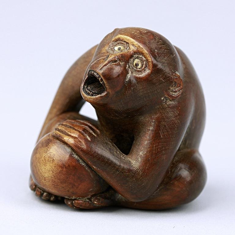 ANTIQUE JAPANESE CARVED FRUITWOOD NETSUKE: of a monkey. H: 1 5/8 in.(4cm)
