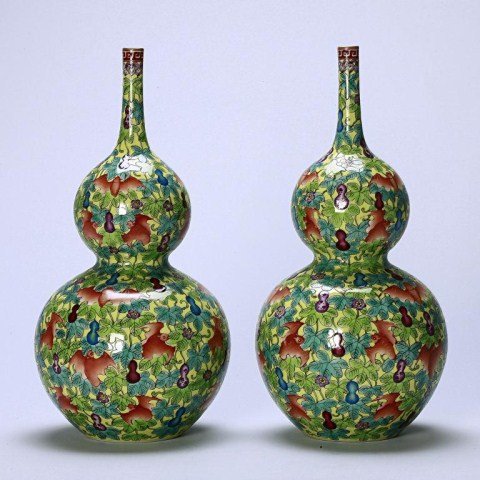 PAIR OF CHINESE DOUBLE GOURD ROSE WATER VASES: Of svelte double gourd form, each vase enameled with lush leaves adorned with hanging aubergine and turquoise miniature double gourds and iron red bats on lemon yellow ground, the long slender neck le