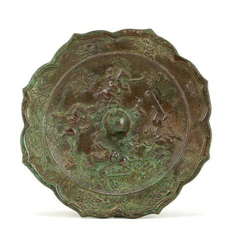 ANTIQUE CHINESE IRON MIRROR: The eight-petal water chestnut flower rim, centered with a pierced knob, surrounded by equestrians playing jiju, with some holding the stick high to seize the ball; some leaning forward to strike the
